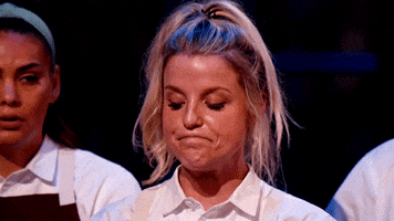 Reality TV gif. A blonde female chef puts on a brave face, nodding and grimacing in response to criticism.