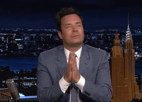 Tonight Show gif. Jimmy Fallon on the Tonight Show has his eyes closed and his hands are in prayer position as he looks both grateful and hopeful. He kisses his hands and sends it out to us.
