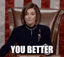 Video gif. Nancy Pelosi sits in a brown leather chair, looking out at her audience. Suddenly, she looks stern and points to her left with a note card. Text, "You better."