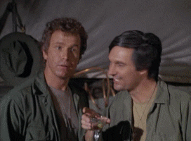 Pohyblivý obrázek se dvěma herci ze seriálu MASH zvedajícími sklenky s Martini k přípitku.