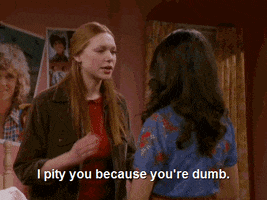 TV gif. Laura Prepon as Donna on That '70s Show speaks sternly to Mila Kunis as Jackie, "I pity you because you're dumb," which appears as text.