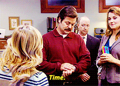 Parks and Recreation gif. Nick Offerman as Ron looks at his watch and says "Time," halting Amy Poehler as Leslie, and then he says "Thank you, Leslie."