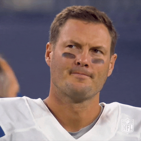 Sports gif. Phil Rivers of the Indianapolis Colts has black paint on his cheeks and he looks at something, furrowing his brows tight, and shaking his head.