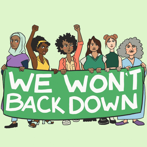 Digital art gif. Six cartoon women of different ages and races stand holding a large green sign that says, "We won't back down." The women have defiant looks on their faces and two of them have their fists raised in protest.
