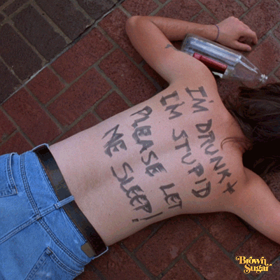 Movie gif. Brown-haired, shirtless person in Candyman lies sprawled out on brick pavement, face-down, with an empty 40-ounce bottle nearby and text written on his back. Text, "I'm drunk and I'm stupid, please let me sleep!"