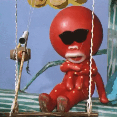 Video gif. A person in a red octopus costume rips off black sunglasses to reveal its wide shocked eyes. 