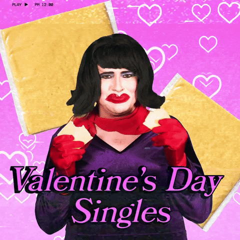 Video gif. A man wearing a red wig, red gloves, and a red scarf holds a piece of cheese in each hand and munches on them while raising their eyebrows at us. Text, "Valentine's Day Singles."