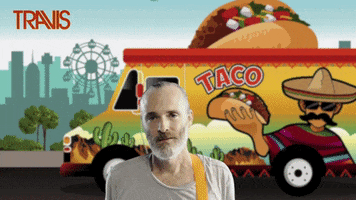 Celebrity gif. Travis singer Fran Healy stands in front of a colorful cartoon taco truck that has a giant taco topper. He stares hungrily at a taco descending from the sky and turns back to look at the truck. In a festive front, text reads, "Taco Tuesday."