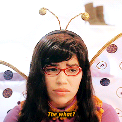 TV gif. America Ferrera as Betty in Ugly Betty. She's a bumblebee and has bee antenna on with wings. She looks sullen as she looks up and says, "The what?"
