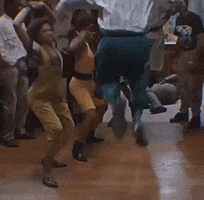 TV gif. From the show House Party, a group crowds together and creates a circle around two men shuffling their feet in sync. Everyone appears to be having loads of fun.