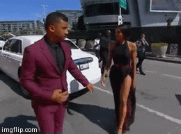 Celebrity gif. Russell Wilson and Ciara are watching matching maroon-themed outfits and they head onto the red carpet together.