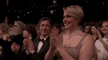 Oscars 2024 GIF. Greta Gerwing, at the Oscars, gives a sweetly emotional standing ovation.
