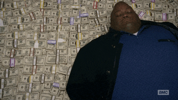 TV gif. Lavell Crawford as Huell on Breaking Bad. He is laying supine on a stacks of money and he rolls his head and shoulders around, trying to get comfortable.