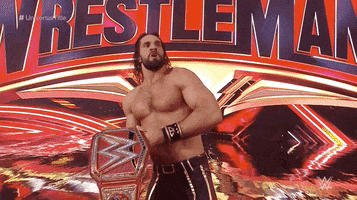 Sports gif. Seth Rollins on stage holding the title belt as the winner of Wrestlemania 35. He lifts it in the air to show the crowd and roars, "WE DID IT!"