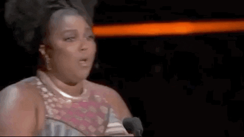 Celebrity gif. Lizzo wears a shiny sleeveless gown, shakes her head emphatically, and pumps an award statuette in the air while shouting, "Let's go!"