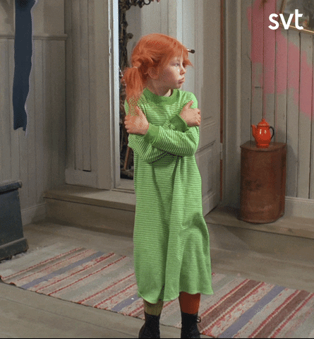 TV gif. Inger Nilsson as Pippi Longstocking glances around looking cold, as her knees tremble and she wraps her arms around her body tightly on loop. 