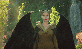 Movie gif. Angelina Jolie as Maleficent in Maleficent Mistress of Evil walks toward us with a serious, stoic expression. She says, “well, well.”