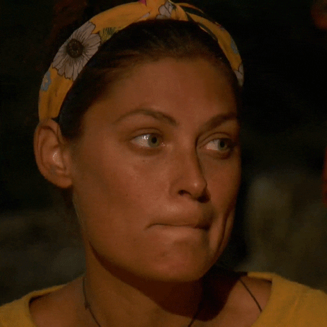 Reality TV gif. Michele Fitzgerald on Survivor raises her eyebrows and chews her bottom lip glancing around as if unimpressed.  