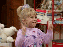 TV gif. Mary-Kate or Ashley Olsen as Michelle Tanner in Full House smiles and dances with pointer fingers pointing in the air. 