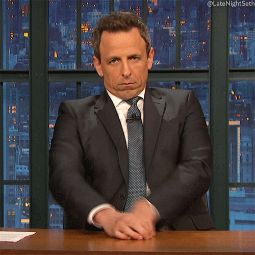 Late Night gif. A grumpy Seth Meyers folds his arms and frowns at us, making a double chin.