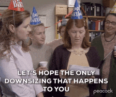 The Office gif. Women wearing birthday hats stand around Kate Flannery as Meredith as she reads a card, with some disappointment, "Let's hope the only downsizing that happens to you is that someone downsizes your age," which appears as text. Our focus goes to Angela Kinsey as Angela who glances off to make eye contact with us.