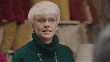 SNL gif. Kate McKinnon, in a platinum blonde bob wig, blinks slowly and expectantly with a straight face.