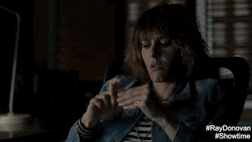 TV gif. Katherine Moennig, as Lena on Ray Donovan, slouches in an office chair fiddling with something in her hand, and then looks up somewhat disgustedly.