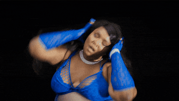 Ad gif. Lizzo is dressed up in blue lingerie and she closes her eyes and touches her head with both hands, sexily modeling her set for the Savage x Fenty show.
