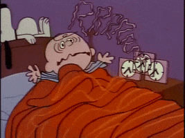 Cartoon gif. Charlie Brown is asleep in bed until a square alarm clock goes off. He wakes with a start, looks around, and turns off the alarm, then frowns and checks the time. Snoopy, asleep on top of the bed's headboard, sleeps right through it. Text: A drawn-out "Rrr" visual sound effect.