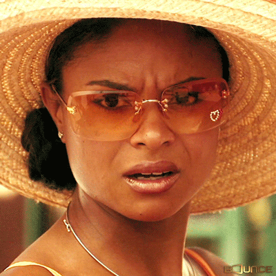 TV gif. Woman wearing sunglasses and a straw sunhat furrows her brow and drops her jaw in disgust, and someone's hand reaches in and taps her chin to shut her mouth.