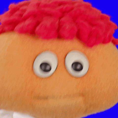 Video gif. A red curly haired puppet bobbles its head and says, “I’m sorry!”