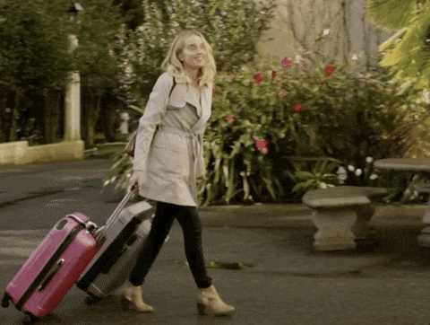 A person dragging two suitcases by Hallmark Channel