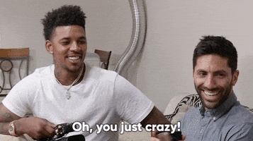 Reality TV gif. Nev Schulman and Nick Young in Catfish sit and laugh with a person who appears to be scrolling their phone. Nick smiles and says, "Oh, you just crazy!"