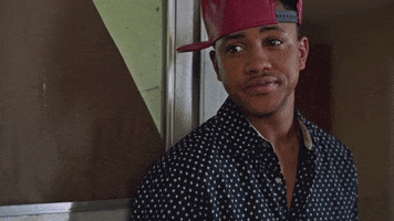 Movie gif. Tequan Richmond as Gabe in "Savage Youth" leans against a wall, glancing over, then slowly nodding while turning his head away.