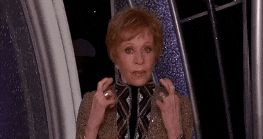 Celebrity gif. Carol Burnett at the Golden Globes appears on stage, staring at us intently and crossing her fingers in hopeful anticipation.