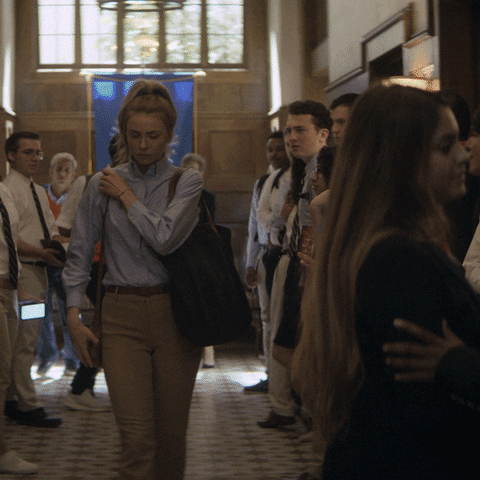 TV gif. Anjelica Fellini as Maddie on Teenage Bounty Hunters walks down the hallway of her high school and suddenly is grabbed by another student who pulls her aside. Maddie is annoyed, but the student looks up to her with a genuine smile and says, “Just know I'm praying for you.”
