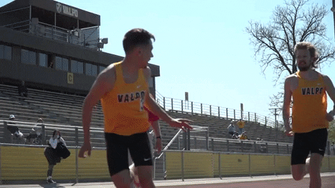 Track running athlete handing off relay baton to another track runner - GIF by Valparaiso University