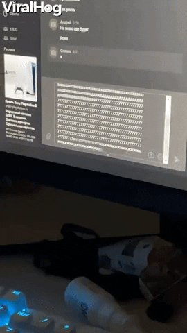 Video gif. Closeup of a computer as a stream of text is typed rapidly onscreen. We zoom out to a cat perched atop the keyboard, watching the monitor intently.