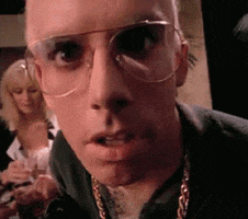 TV gif. Actor Ben Stiller on The Ben Stiller Show dons a platinum blonde wig and aviator glasses. "Do it" he urges as he raises his eyebrows dramatically.