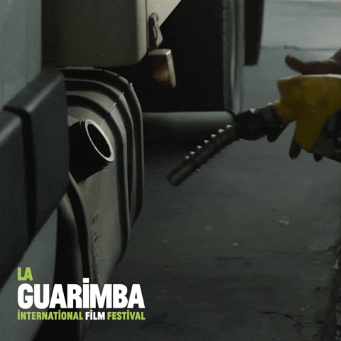 Movie gif. In a Fast and Furious clip, a man inserts a gas nozzle into a truck’s gas tank, preparing to pump gas.
