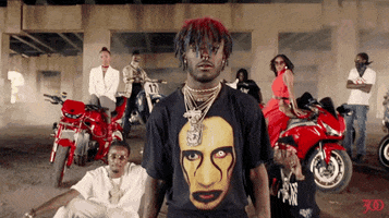 Music Video gif. Lil Uzi Vert in the music video for Bad and Boujee. The camera zooms in on him as he smiles and give us a small shrug.