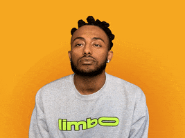 Video gif. Singer Amine, against an orange-yellow background, slaps his hand over his face and shakes his head condescendingly.
