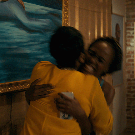 TV gif. DeWanda Wise as Nola in She's Gotta Have It smiles ecstatically as she hugs a woman tightly while they rock back and forth together.