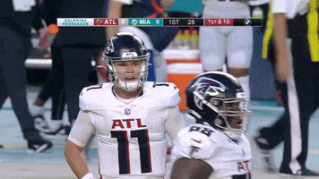 Sports gif. Atlanta Falcons quarterback Logan Woodside claps his hands together as he yells out at other players on the field in a fired-up encouraging sort of way. 