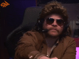 Video gif. A man wearing aviators and a headset leans back in his chair and smiles while saying, "Well, well, well."