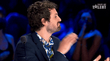 Reality TV gif. Frank Matano as a judge on Italia's Got Talent looks convinced, his chin in a thoughtful frown as he claps.