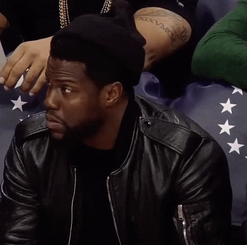 Celebrity gif. Kevin Hart sits at a basketball game, leaning forward in his seat. He looks around and nods, pretty impressed by what he just saw. 