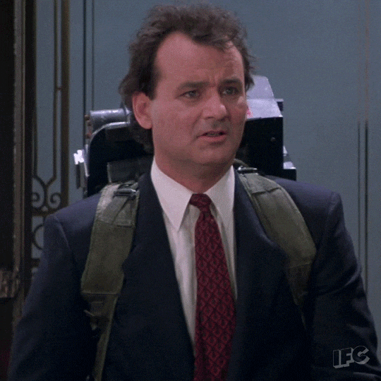 Movie gif. Bill Murray as Dr. Venkman in Ghostbusters looks around confused, then smiles and nods his head.