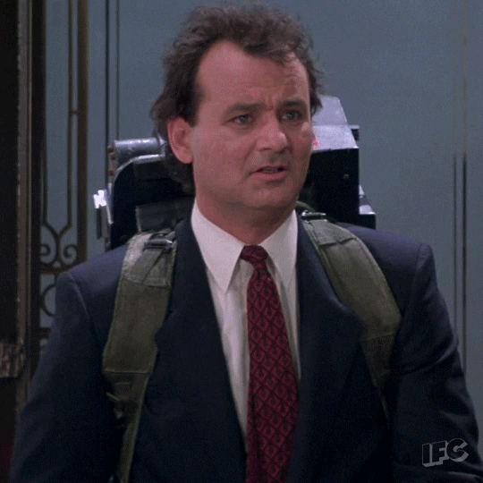 Movie gif. Bill Murray as Dr. Venkman in Ghostbusters looks around confused, then smiles and nods his head.