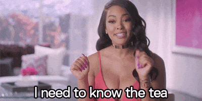 Reality TV gif. Malaysia Pargo on Basketball Wives tilts her head to the side with a big, fake smile on her face. She hands her hands up and sassily points as she says, “I need to know the tea.”